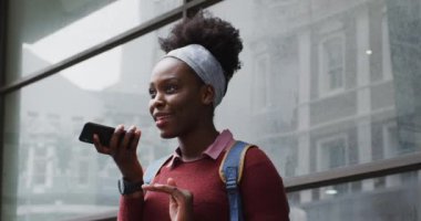 Sokakta akıllı telefonuyla konuşan Afrikalı Amerikalı.