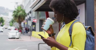 Sokakta akıllı telefonunu kullanan Afrikalı bir Amerikalı.