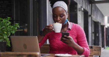 Afro-Amerikalı bir kafede oturuyor.