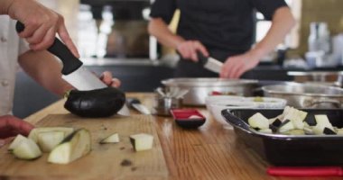 Çeşitli gruplara ders veren beyaz kadın şef. Yemek hazırlamak ve gülümsemek. Profesyonel bir mutfakta çalışıyorum..