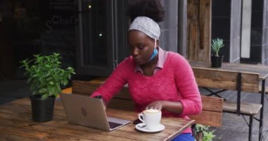 Afro-Amerikalı bir kafede oturuyor.