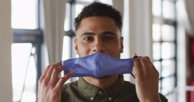 Maske takan melez bir adamın portresi. Coronavirus covid 19 salgını sırasında profesyonel bir mutfakta sağlık ve hijyen..