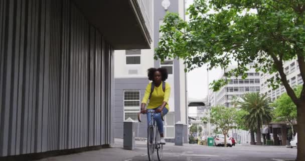 Mujer afroamericana montando bicicleta en la calle — Vídeos de Stock
