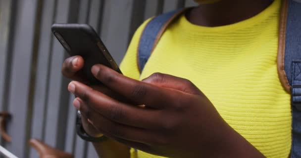 Африканская американка использует смартфон на улице — стоковое видео