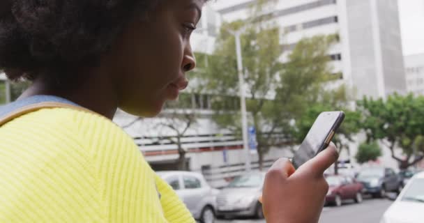 Afričanky americká pomocí svého smartphonu v ulici — Stock video