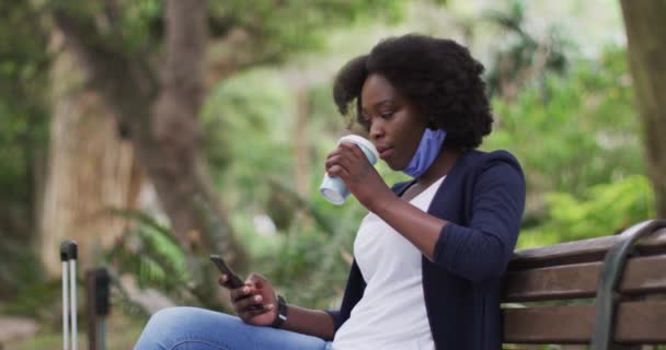 Africano americano mulher vestindo máscara facial no parque — Vídeo de Stock