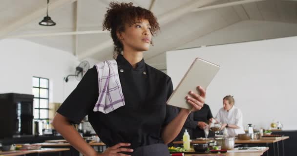 Mixed Race Female Chef Using Digital Tablet Preparing Dishes Smiling — Stock Video