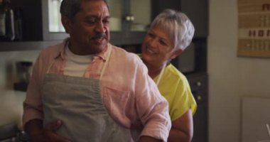 Mutfakta önlük giyen son sınıf melez çift.