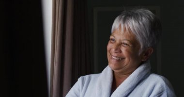 Evde pencereden el sallayan son sınıf melez kadın.