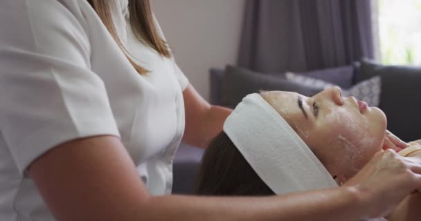 白人妇女躺在后面，美容师给她做了个面部护理 — 图库视频影像