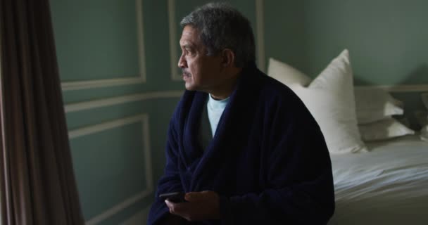 Senior blandras man sitter på sängen tittar bort — Stockvideo