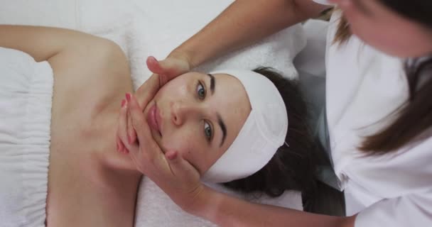 白人妇女躺在后面，美容师给她做了个面部护理 — 图库视频影像
