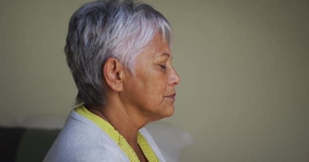 Ηλικιωμένη γυναίκα μικτή φυλή με πονοκέφαλο κάθεται αγγίζοντας φρύδι — Αρχείο Βίντεο