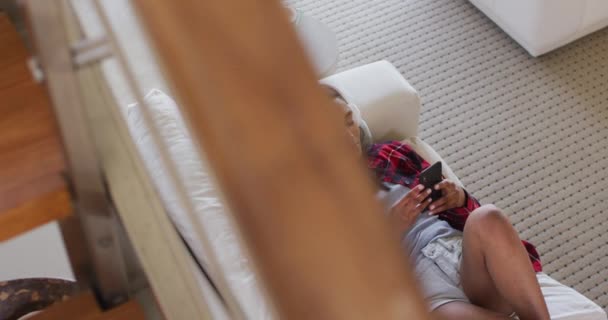 혼합 된 인종 여성 스마트폰을 사용하고 헤드폰으로 음악을 듣는 모습 — 비디오