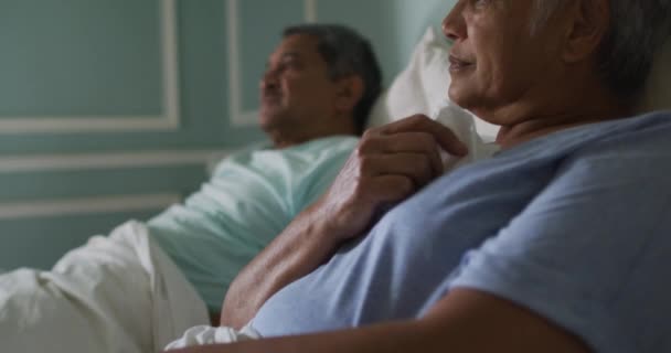 Pasangan ras campuran senior keduanya sakit di tempat tidur — Stok Video
