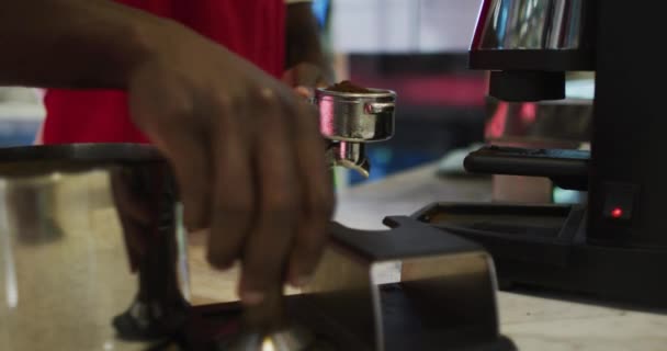 Middel av afrikansk amerikansk man barista gör kaffe i kaffemaskinen — Stockvideo