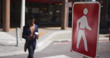 Afro-Amerikalı işadamı elinde kahve tutarken akıllı telefon kullanıyor.