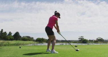Beyaz kadın golf oynuyor. Sığınaktan ateş ediyor.