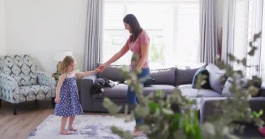 Kafkas anne ve kızı oturma odasında dans ederken eğleniyorlar.