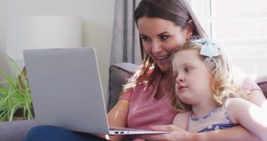 Kafkas anne ve kızı dizüstü bilgisayar kullanarak eğleniyor.