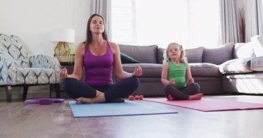 Kafkas anne ve kızı oturma odasında meditasyon yaparken eğleniyorlar. Coronavirus covid 19 salgını süresince evde iyi vakit geçirmenin keyfini çıkarıyorum..