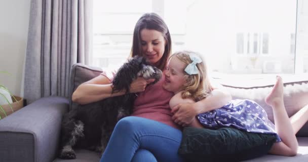 Caucasian mother and daughter having fun playing with a dog — Stock Video