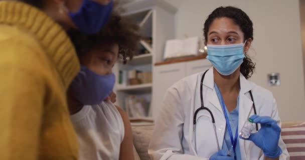 Vegyes fajú női orvos arcmaszkot visel, és otthon adja be az injekciót — Stock videók