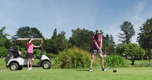 Dvě bělošky hrají golf, jedna střílí z bunkru — Stock video