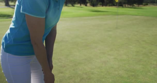 Caucásico jugador de golf femenino tomando tiro de bunker de pie en el campo de golf — Vídeos de Stock