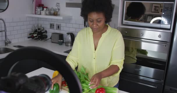 Africano americano hembra plus tamaño vlogger grabación un vídeo acerca de cocinar — Vídeos de Stock