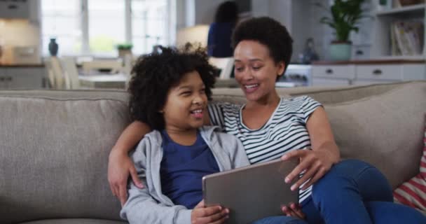 Raza mixta madre e hija usando una tableta digital — Vídeo de stock