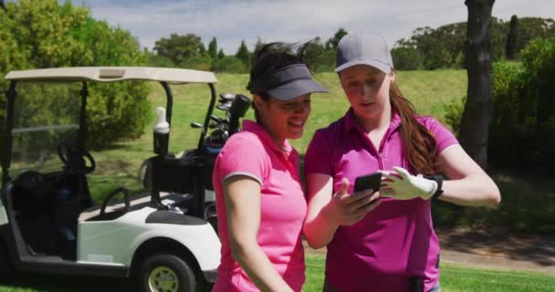 Dvě kavkazské ženy hrající golf pomocí chytrého telefonu — Stock video