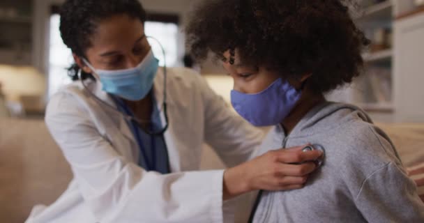 Médico Femenino Raza Mixta Con Máscara Que Examina Una Chica — Vídeos de Stock