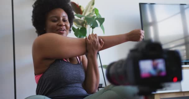 Africano americano hembra plus tamaño vlogger grabación un vídeo acerca de entrenamiento — Vídeos de Stock