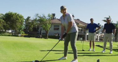 Güneşli bir günde golf sahasında golf antrenmanı yapan beyaz bir kadın. emeklilik sporları ve aktif yaşlı yaşam tarzı.