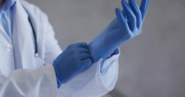 Tıbbi eldiven ve maske takan beyaz erkek doktor. Coronavirüs covid 19 salgını sırasında sağlık hizmetleri koruması.