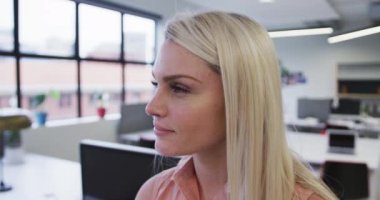 Kafkas iş kadını portresi. Kameraya bakıyor ve modern ofiste gülümsüyor.