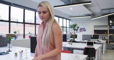 Kafkas iş kadını kameraya bakıyor ve modern ofiste gülümsüyor.