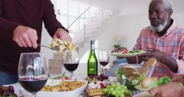 Masanın başında oturan, şarap içen ve akşam yemeği yiyen farklı yaşlı çiftler. Huzurevinde sağlık hizmetleri.