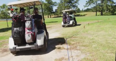 Golf sahasında golf sopalarıyla golf arabası süren son sınıf öğrencileri. emeklilik sporları ve aktif yaşlı yaşam tarzı.