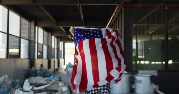 Mujer de raza mixta sosteniéndonos bandera corriendo por un edificio vacío — Vídeos de Stock