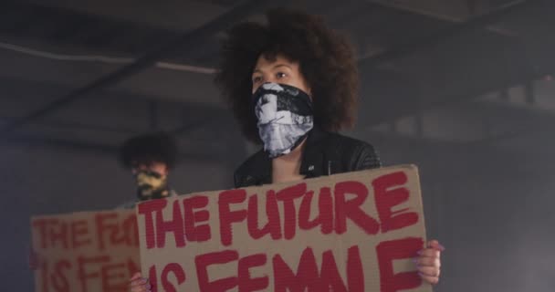 Homme et femme de race mixte portant des masques de visage portant des signes de protestation — Video