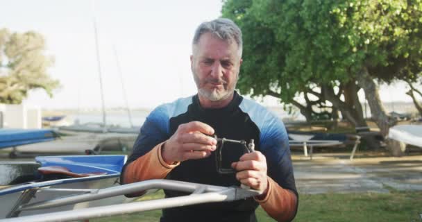 Älterer Kaukasischer Mann Bereitet Ruderboot Für Das Wasser Vor Sport — Stockvideo