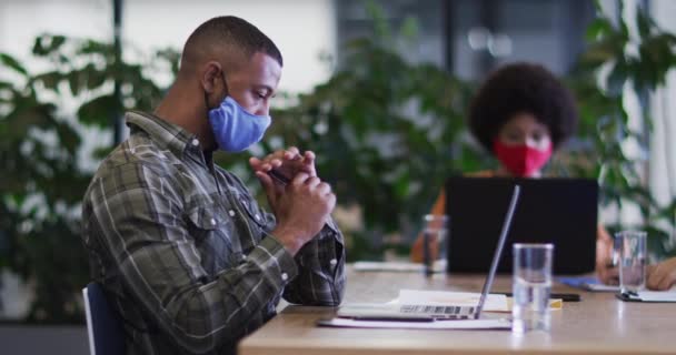 Zróżnicowani Biznesmeni Maskach Siedzą Laptopach Przeglądają Papiery Biurze Higiena Miejscu — Wideo stockowe