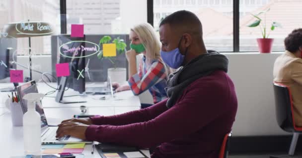 Mixed Race Businessman Wearing Face Mask Sitting Using Laptop Smartphone — Stock Video