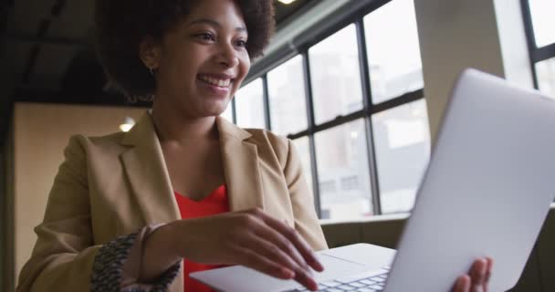 Mieszana bizneswoman rasy stoi przy użyciu laptopa w nowoczesnym biurze — Wideo stockowe