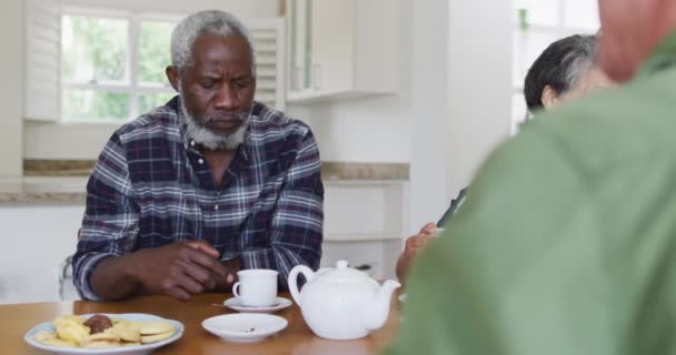 Zwei Unterschiedliche Seniorenpaare Sitzen Hause Einem Tisch Und Trinken Gemeinsam — Stockvideo