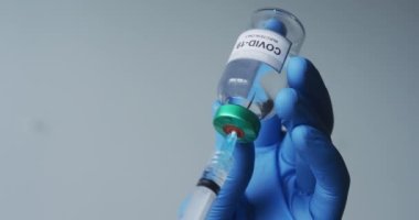 Beyaz erkek doktor koruyucu eldivenler giyip şırıngayı kovid 19 aşısıyla dolduruyor. Coronavirus covid 19 salgını sırasında tıbbi profesyonel sağlık çalışanı hijyeni.