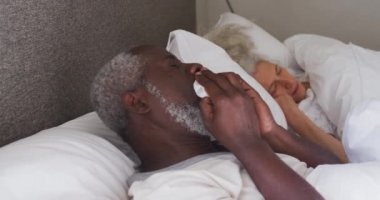 Hasta kıdemli Afro-Amerikan adam evde yatakta yatarken...