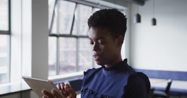 Smíšené rasy podnikatelka stojící pomocí digitálního tabletu v kanceláři — Stock video
